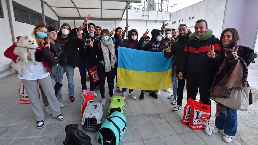 Tunisian students evacuated from Ukraine pose with the Ukrainian flag upon their arrival at the Tunis-Carthage airport on March 1, 2022.