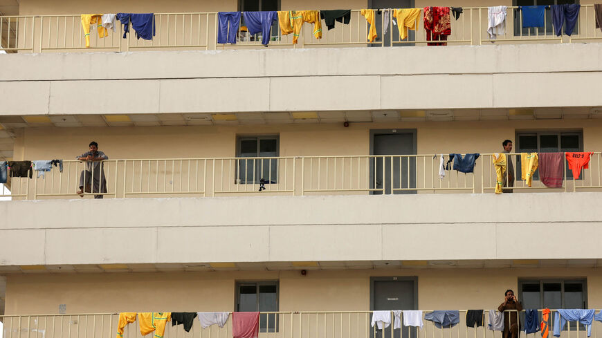 Workers hang their laundry out to dry on the railings of their labor accommodation, Dubai, United Arab Emirates, May 27, 2022.