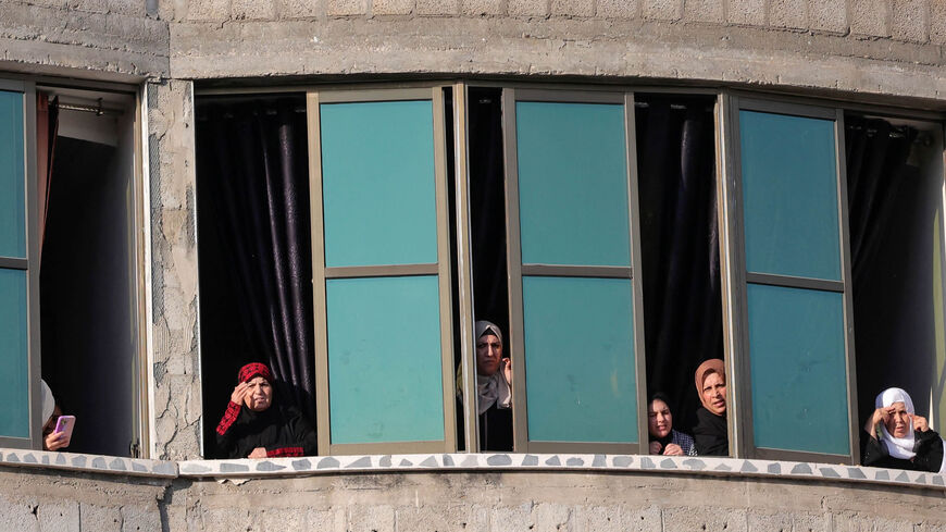 Palestinian women watch from a building as demonstrators rally at Falluja cemetery in Jabalia,  where five youths were killed during the latest round of conflict between Israel and Palestinian militants before a cease-fire, Gaza Strip, Aug. 16, 2022.