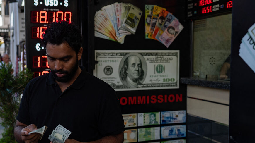 A customer holds US dollar banknotes outside a currency changer as Turkey's economy is suffering its biggest economic crisis in decades, Istanbul, Turkey, Sept. 6, 2022.