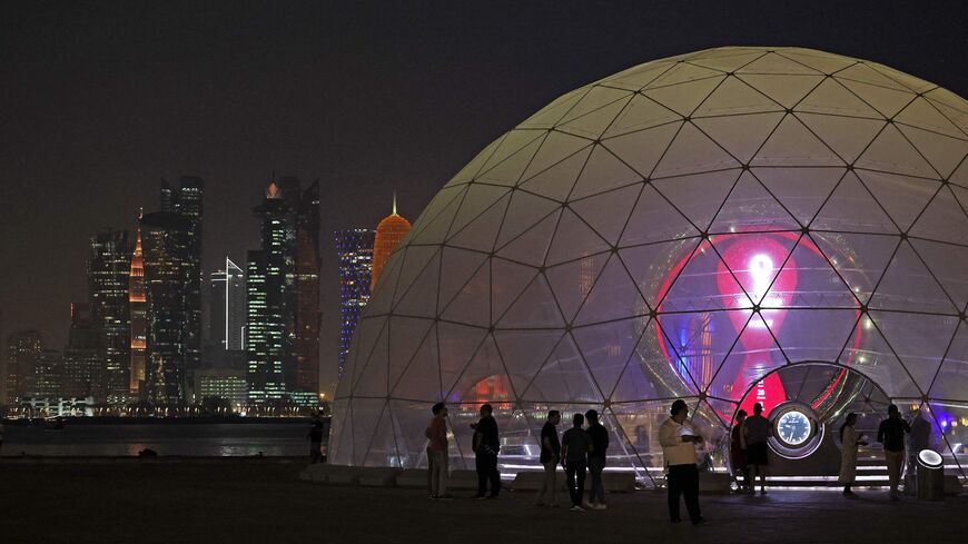 People gather next to the Qatar 2022 FIFA World Cup countdown clock in Doha, on Sept. 12, 2022. 