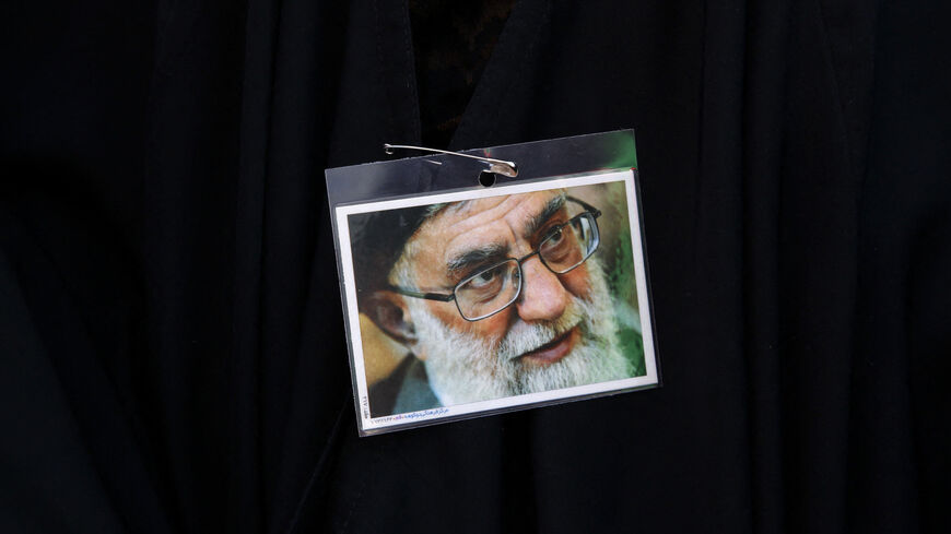 An Iranian pro-government protester wears a pin displaying a portrait of Supreme Leader Ayatollah Ali Khamenei.