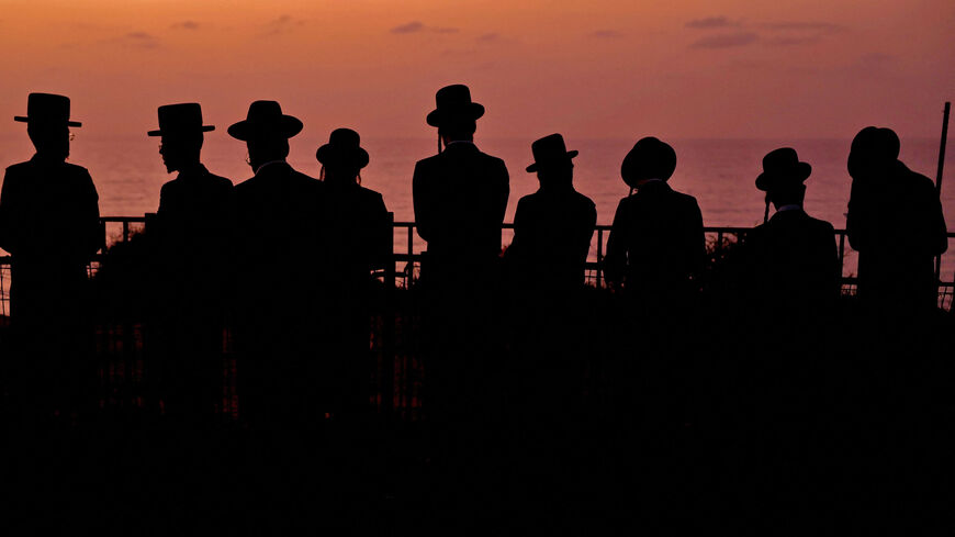 Ultra-Orthodox Jewish men and children perform the "Tashlich" ritual, during which "sins are cast into the water to the fish," ahead of the Day of Atonement (Yom Kippur), Netanya, Israel, Oct. 3, 2022.