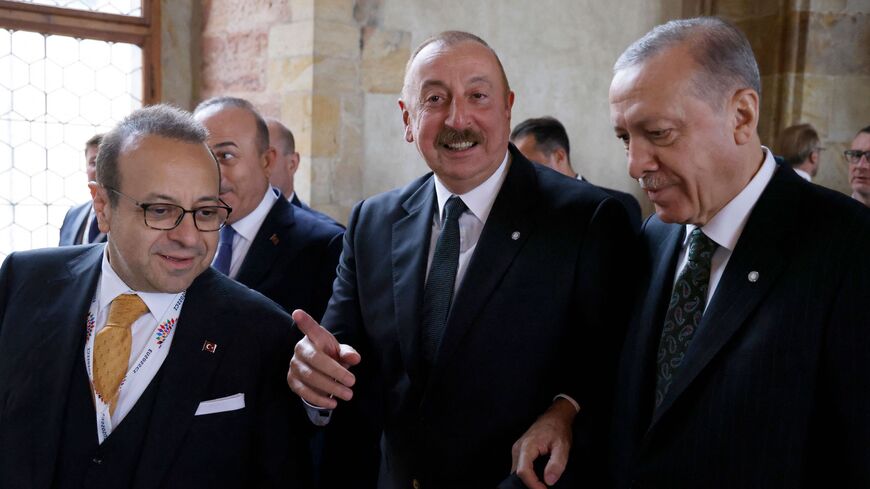Azerbaijan's President Ilham Aliyev (C) speaks with Turkish President Recep Tayyip Erdogan (R).