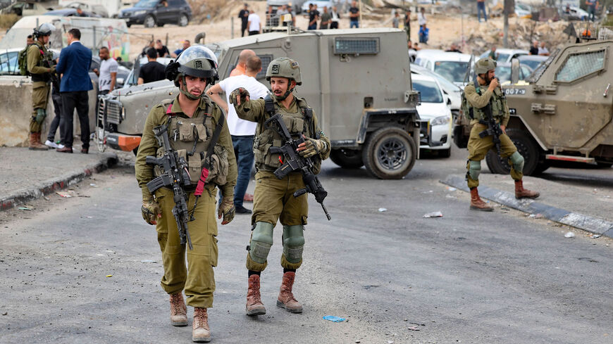 Israeli soldiers stand guard at one of the entrances of the Shuafat refugee camp, East Jerusalem, Oct. 9, 2022.