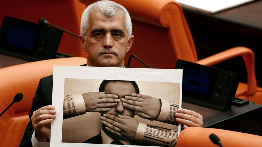 HDP MP Omer Faruk Gergerlioglu holds a photograph depicting censorship.
