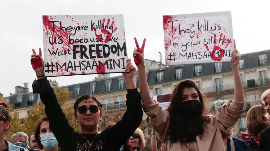 People hold up placards during a rally in support of the demonstrations in Iran, at The Place de la Republique in Paris, on Oct. 29, 2022. 