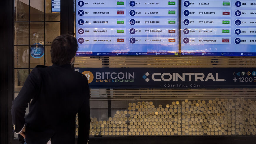 A man looks at cryptocurrency prices in a window of a cryptocurrency exchange office, Istanbul, Turkey, Oct. 19, 2021.