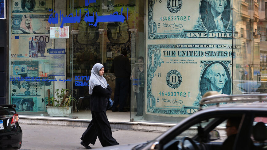 An Egyptian woman walks past an exchange store in Cairo on Jan. 6, 2013.
