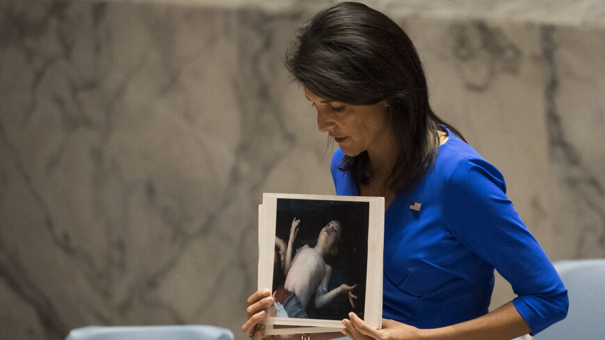 US Ambassador to the UN Nikki Haley holds a photo of a victim of the 2013 Syrian Ghouta chemical attack.