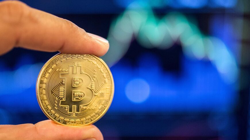 Picture taken on Feb. 6, 2018, shows a person holding a visual representation of the digital crypto-currency Bitcoin,
