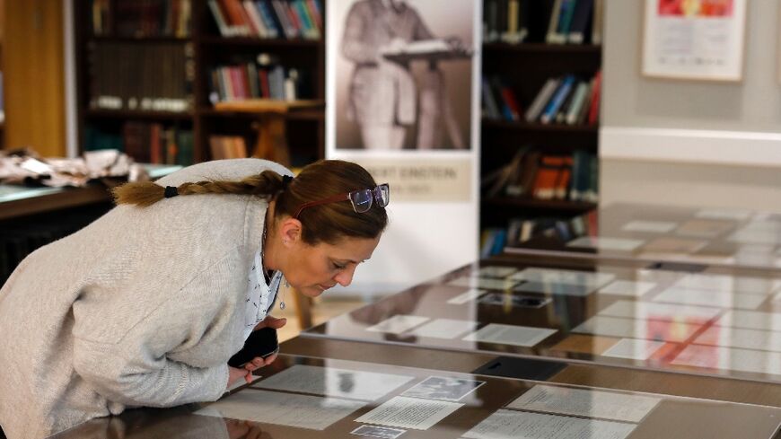 In this file photo from March 6, 2019, a woman checks Albert Einstein manuscripts at the Hebrew University in Jerusalem