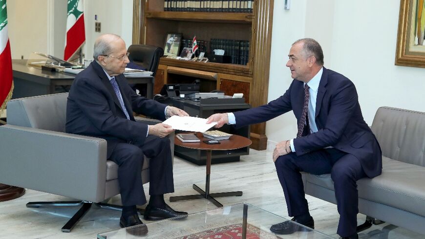 Lebanon's lead negotiator Elias Bou Saab (R) hands the final draft of the US-brokered maritime border deal with Israel to President Michel Aoun