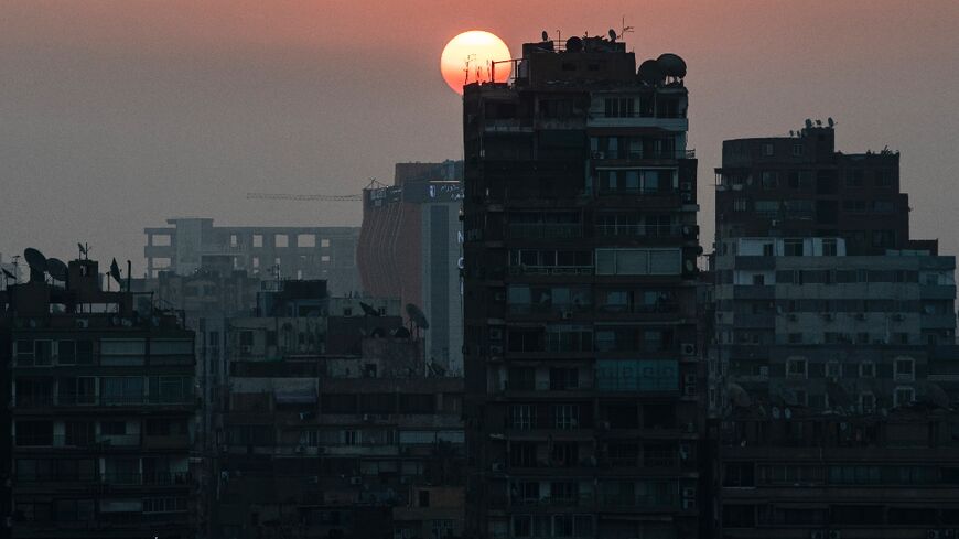 The sun rises behind the skyline of Egypt's capital Cairo and its Nile river island of Manial 