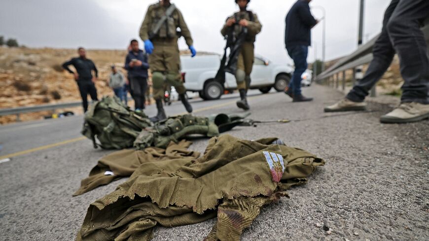 Israeli troops inspect the belongings of a 20-year-old woman soldier who was wounded in a suspected Palestinian car-ramming attack in the occupied West Bank