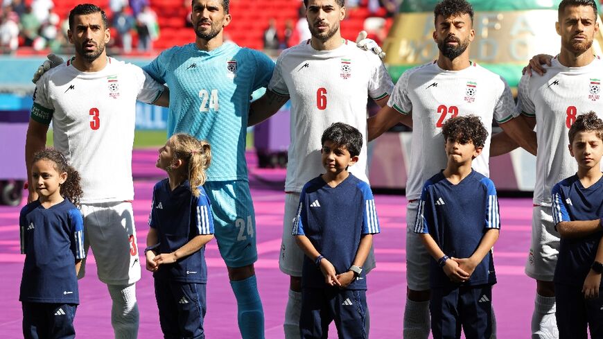 Iran's players sing their national anthem prior to the game against Wales