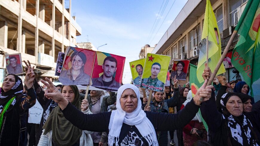 Syrian-Kurdish demonstrators in Qamishli raise pictures of people killed in Turkish strikes