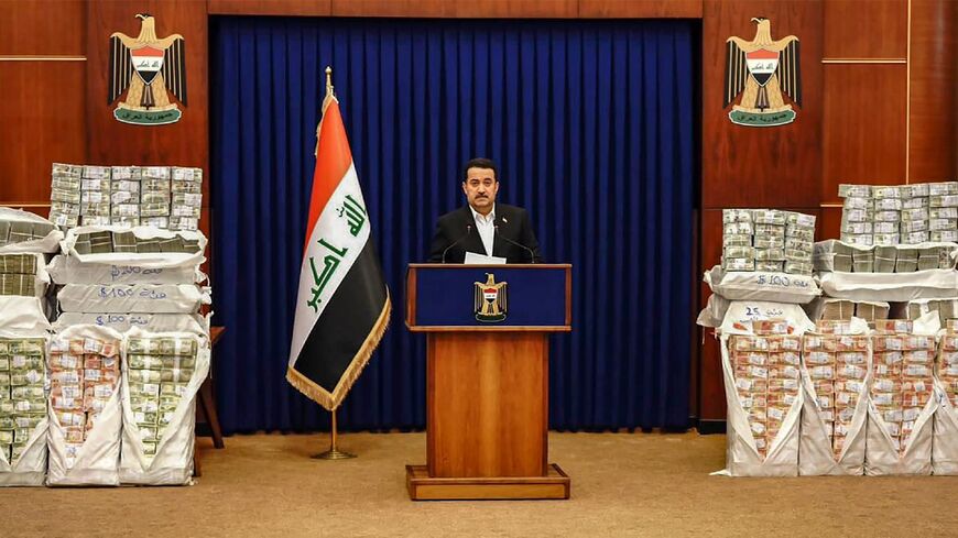 Iraqi Prime Minister Mohammed Shia al-Sudani's comments came during a live address, and he was flanked by piles of banknotes stacked in packages
