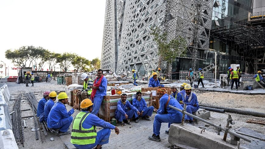 Migrant builders take a break while working at a construction site by the Corniche in Doha during the World Cup