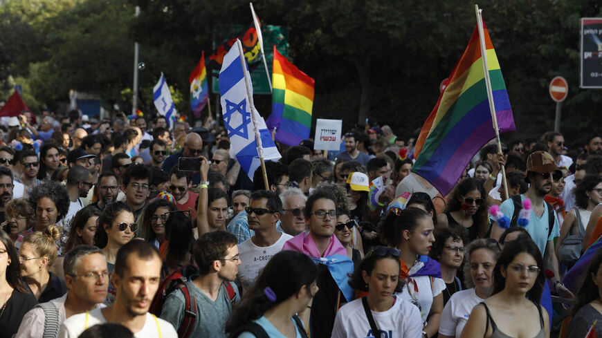 Participants wave Israeli and pride flags during the annual Pride parade, Jerusalem, Aug. 2, 2018.