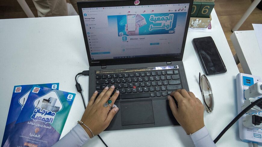 An employee at "al-Gameya", a tech startup the runs an app to facilitate for strangers to create an informal money-pooling association to provide access for money in time of need, uses a computer with the official Facebook page of the application open on a web browser, at the company offices in Egypts capital Cairo on September 12, 2021. - Cash-strapped Egyptians fearful of banks have long relied on a "gameya" to access money in time of need, but now tech startups are cashing in on the practice. Such cooper