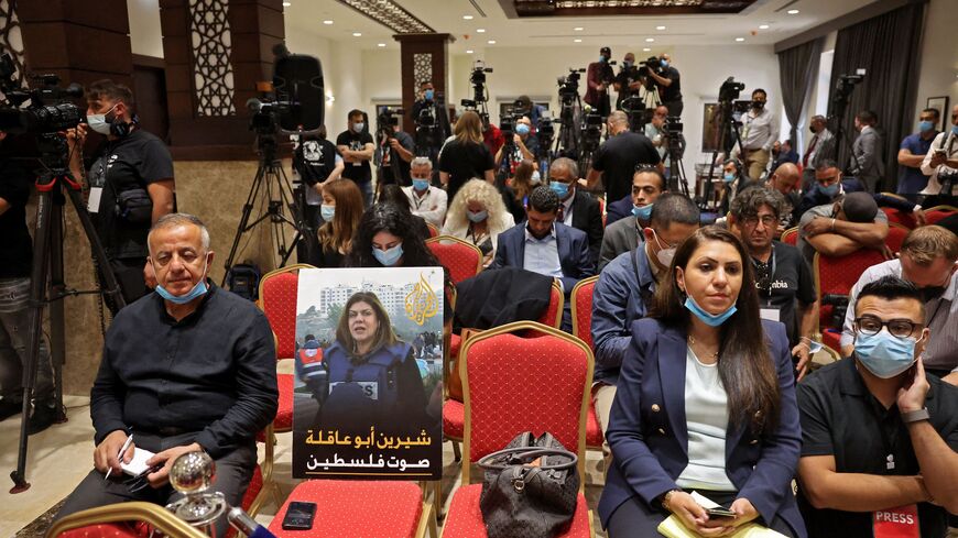 A photo of slain US-Palestinian correspondent Shireen Abu Akleh, with a caption in Arabic reading "Shireen Abu Akleh, the voice of Palestine", is placed amongst reporters ahead of a joint press conference between the US and Palestinian Presidents after their meeting at the Muqataa pesidential compound in the city of Bethlehem in the occupied West Bank on July 15, 2022.