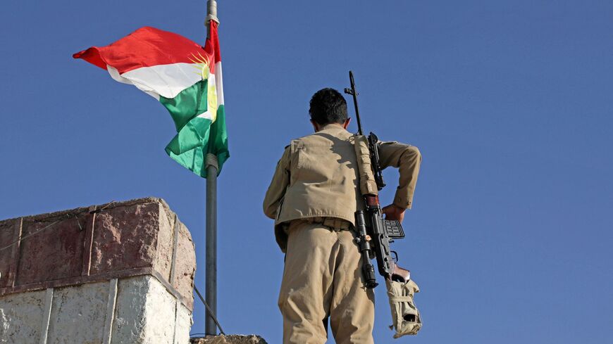 A Kurdish peshmerga fighter stands guard on a building following an Iranian cross-border attack in the town of Koye.