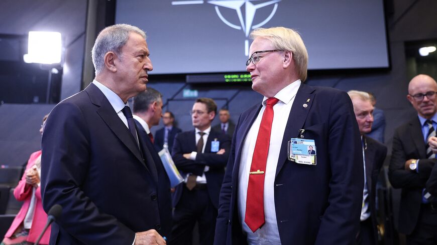Turkish Defense Minister Hulusi Akar (L) speaks with Sweden's Defense Minister Peter Hultqvist ahead of the second day of a meeting of the alliance's Defense Ministers at the NATO headquarters in Brussels on Oct. 13, 2022. 