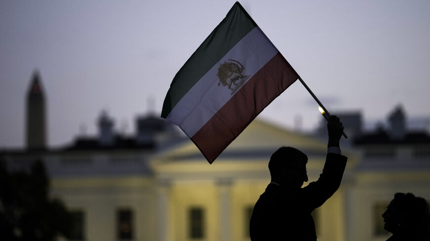 A man holds up an Iranian flag during a vigil in support of protestors in Iran.
