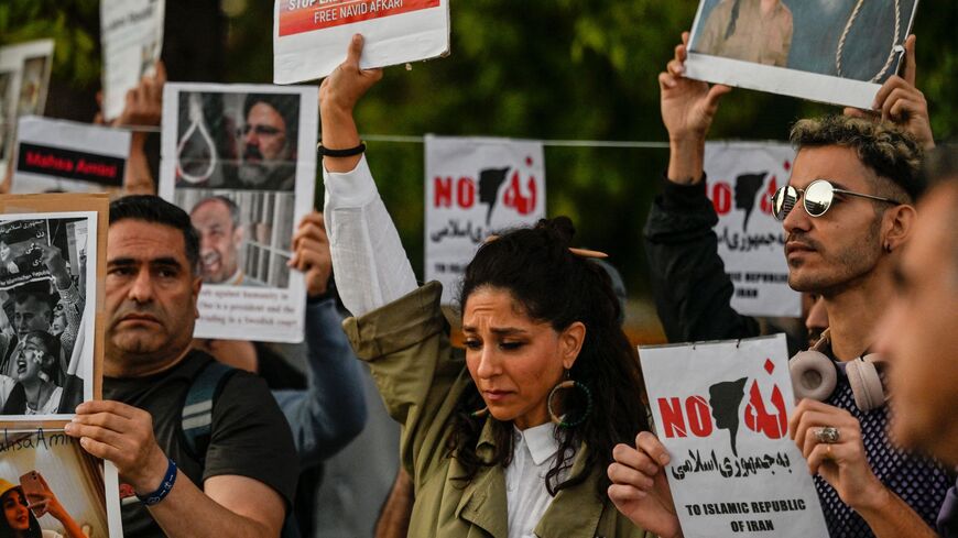 Iranian refugees and Iranians living in Greece hold up placards during a demonstration to commemorate 40 days from the death of Iranian Mahsa Amini while in police custody in Iran, in central Athens on Oct. 29, 2022. 