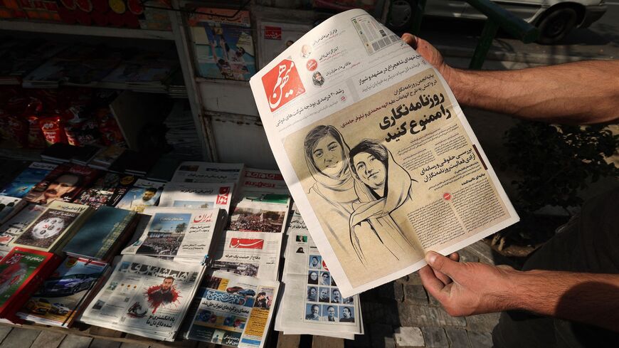 A man in Tehran on Oct. 30, 2022, holds a copy of the Hammihan newspaper, featuring on its cover a headline mentioning the statement by the Tehran journalists' association.