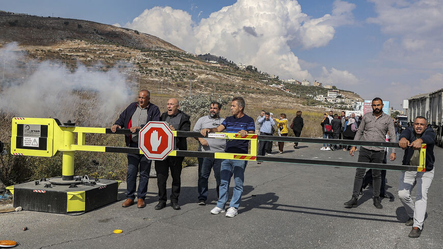 Palestinians gather to demonstrate at the Hawara checkpoint, demanding the reopening of roads around the closed-off city of Nablus, West Bank, Nov. 1, 2022.
