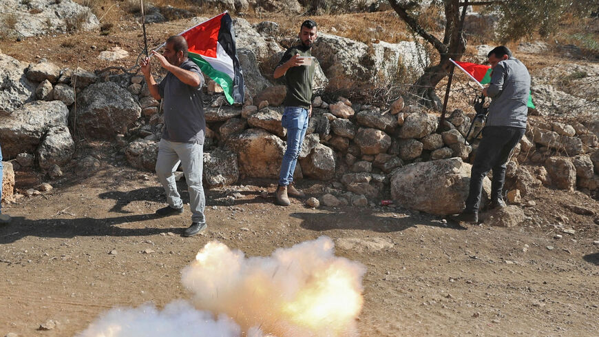 A stun grenade goes off near Palestinian demonstrators during clashes with Israeli forces during a protest against the establishment of Israeli outposts, in Beit Dajan, east of Nablus, West Bank, Nov. 4, 2022.