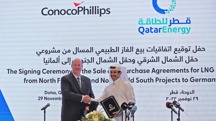 Saad Sherida al-Kaabi (R), Qatar's energy minister and CEO of QatarEnergy, and Ryan Lance (L), CEO of multinational corporation ConocoPhillips, exchange documents during a press conference announcing a new deal, Doha, Qatar, Nov. 29, 2022.