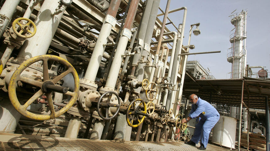 An Iraqi worker adjusts a control valve at the Daura oil refinery, Baghdad, Iraq, Nov. 5, 2009.