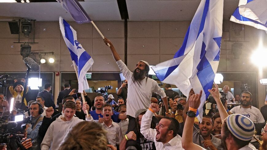 Supporters of Israel's Otzma Yehudit (Jewish Power) far-right party cheer at campaign headquarters after the end of voting on Tuesday