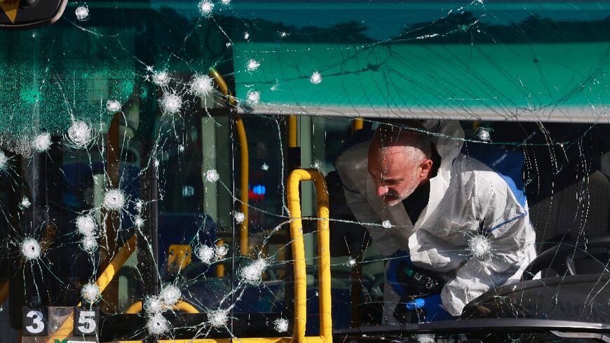 An Israeli forensic scientist inspects the inside of a bus damaged in one of the twin blasts that hit Jerusalem early Wednesday