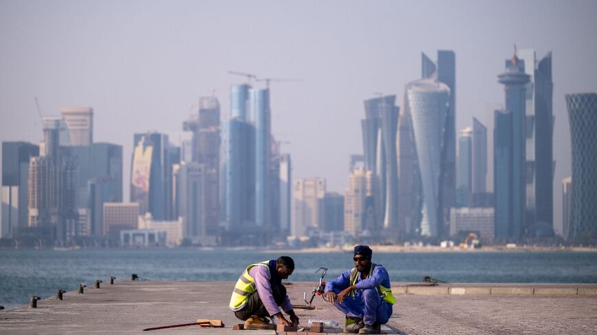 Labourers work near the FIFA World Cup countdown clock in Doha
