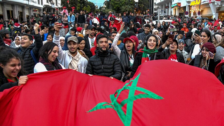 Fans of the Morocco national football team celebrate in the capital Rabat after the squad qualified for the round of 16 of the Qatar 2022 FIFA World Cup