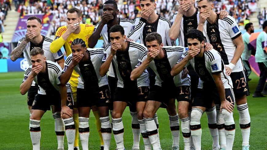 The Germany side cover their mouths as they pose for the team picture ahead of the Qatar 2022 World Cup match against Japan on November 23, 2022