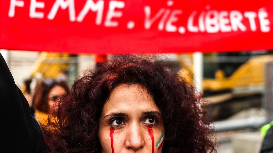 A protestor with red tears painted on her face during a rally in support of the demonstrations in Iran, in Toulouse, south-western France, on December 3
