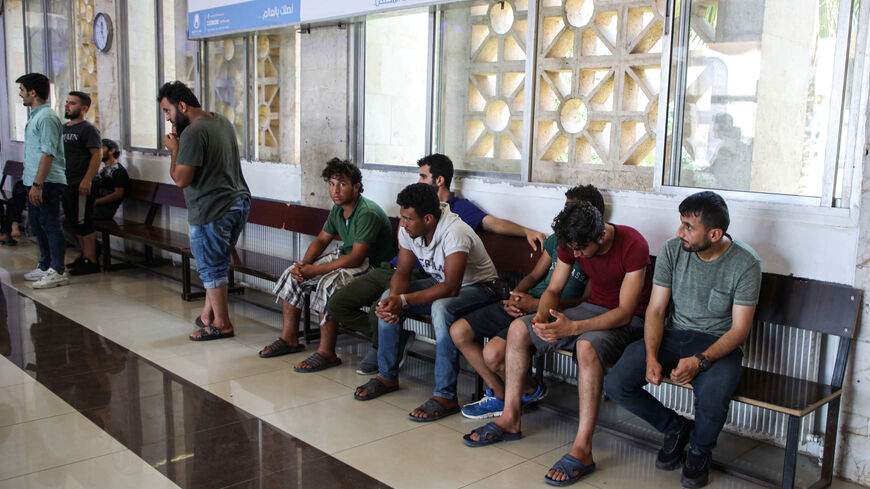 Incoming Syrian refugees who were suddenly deported from Turkey await to register with officials.