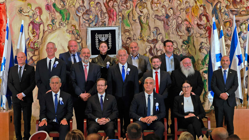 Israeli President Isaac Herzog (seated 2nd L) sits in front of Israel's veteran ex-Prime Minister Benjamin Netanyahu (C) and next to outgoing Prime Minister Yair Lapid (seated 3rd L), as he poses with the heads of all parties of the 25th Knesset at the Marc Chagall hall in the Knesset building, after Israel swore in a new parliament, Jerusalem, Nov. 15, 2022.