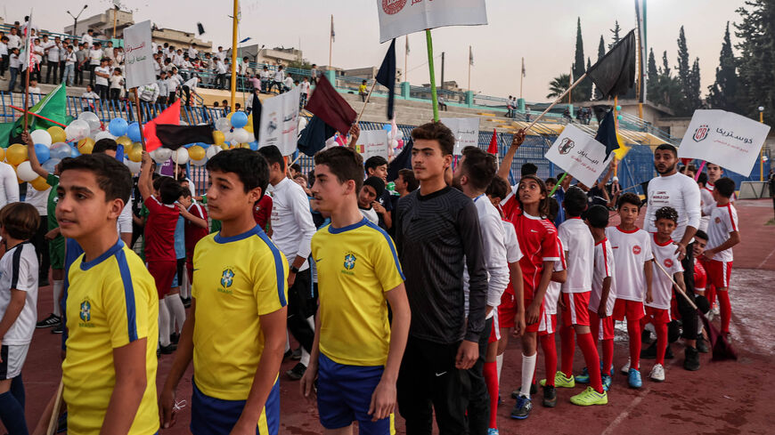 Children wearing the uniforms of national soccer teams playing at the Qatar 2022 FIFA World Cup line up during the opening ceremony of the "Camps World Cup" at the newly reopened Idlib Municipal Stadium, Idlib, Syria, Nov. 19, 2022.