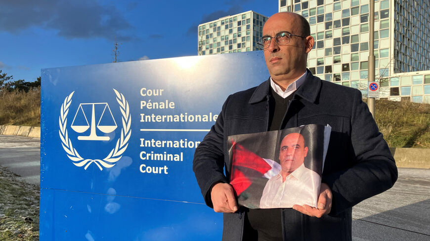 Ghassan Banat holds a picture of his brother, late Palestinian activist Nizar Banat, outside the International Criminal Court, after submitting a case accusing top Palestinian officials over his death in custody, The Hague, Netherlands, December 2022.