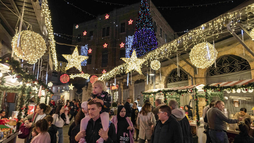 People walk along an alley at a Christmas market in the Christian Quarter of the Old City, Jerusalem, Dec. 15, 2022.
