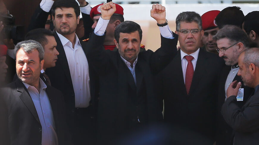 Former Iranian President Mahmoud Ahmadinejad (C) raises his hands toward cheering supporters while standing next to Venezuela's Foreign Minister Elias Jaua (R) as he enters the funeral for Venezuelan President Hugo Chavez at the Military Academy on March 8, 2013 in Caracas, Venezuela. (Photo by Mario Tama/Getty Images)