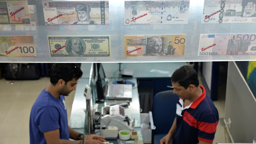 An Indian customer (L) at a foreign exchange outlet changes Indian rupees in Bangalore on August 24, 2013. 