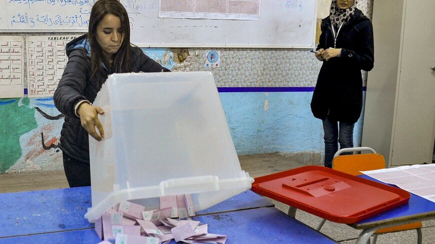 A member of the Tunisian electoral commission counts votes after the ballot in which turnout fell below nine percent of eligible voters