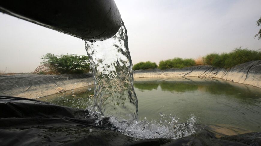Water pours into an irrigation pool in Ghor al-Haditha, south of the Jordanian capital Amman, on April 20, 2021.